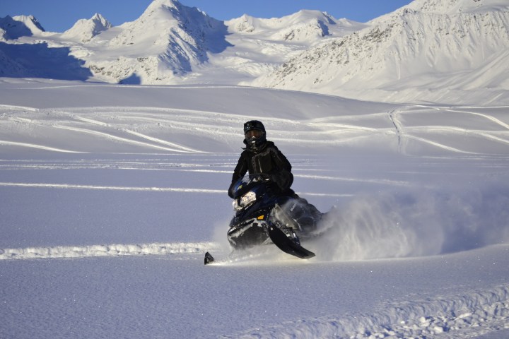 a man riding a snowboard down a snow covered mountain