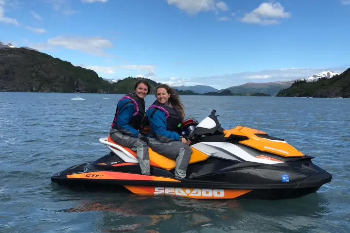 a man riding on the back of a boat on a body of water