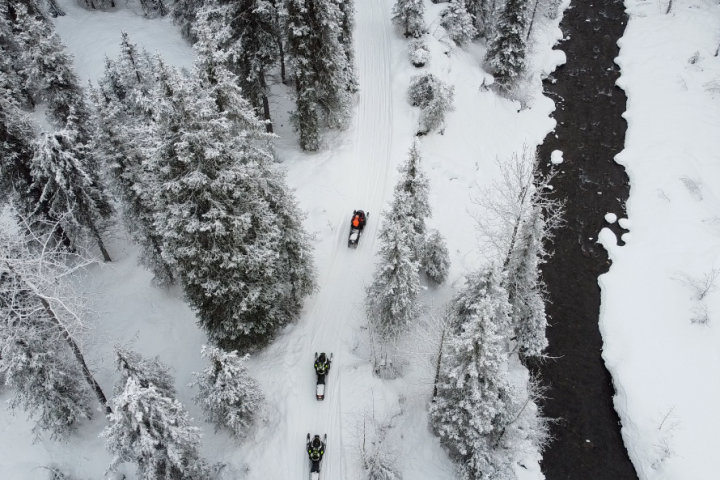 a waterfall with trees on the side of a snow covered slope