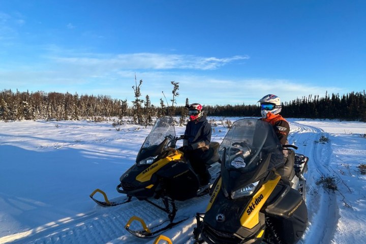 a man riding a motorcycle on the side of a snow covered slope